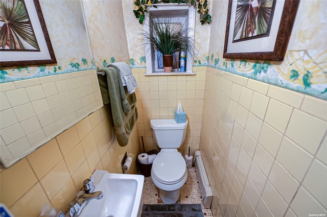 bathroom with tile patterned flooring, toilet, tile walls, and a baseboard heating unit