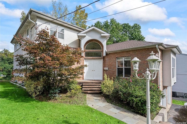 view of front of home with a front lawn and a garage