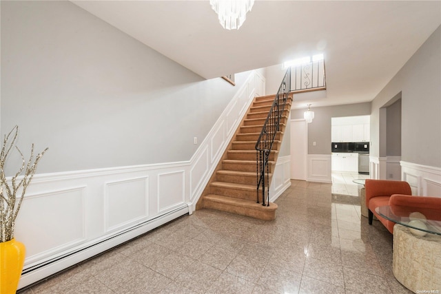 staircase featuring a baseboard heating unit