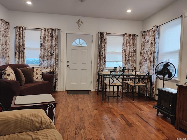 foyer featuring a wood stove, a wealth of natural light, and wood-type flooring