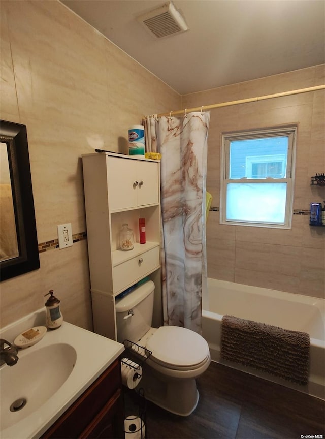 full bathroom featuring vanity, toilet, shower / bathtub combination with curtain, tile walls, and wood-type flooring