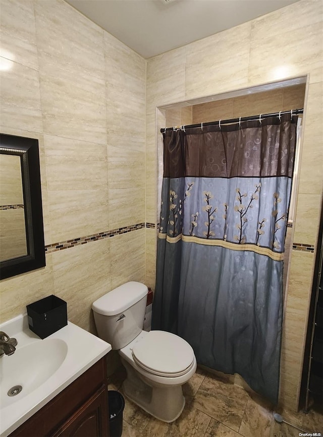 bathroom featuring a shower with curtain, vanity, and tile walls