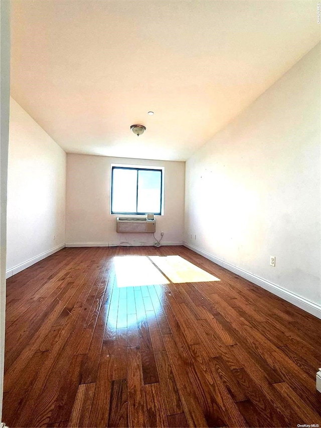 empty room featuring dark hardwood / wood-style floors and a wall mounted AC