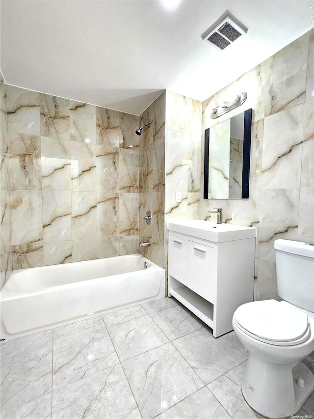 full bathroom with vanity, toilet, tile walls, and tiled shower / bath combo