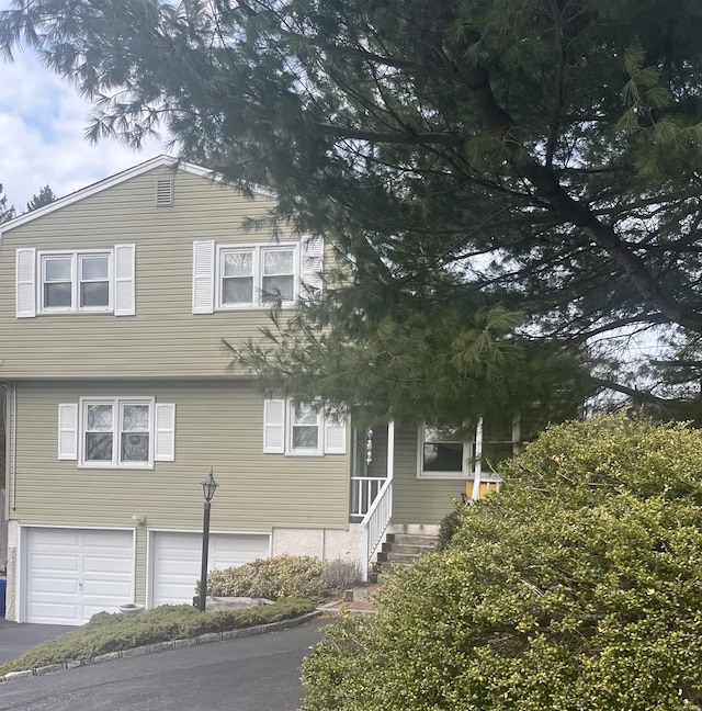 view of front of home featuring entry steps, a garage, and driveway