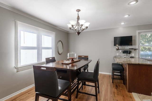 dining room featuring crown molding, light wood-style floors, and a chandelier