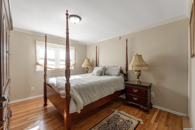 bedroom with wood finished floors, baseboards, and ornamental molding