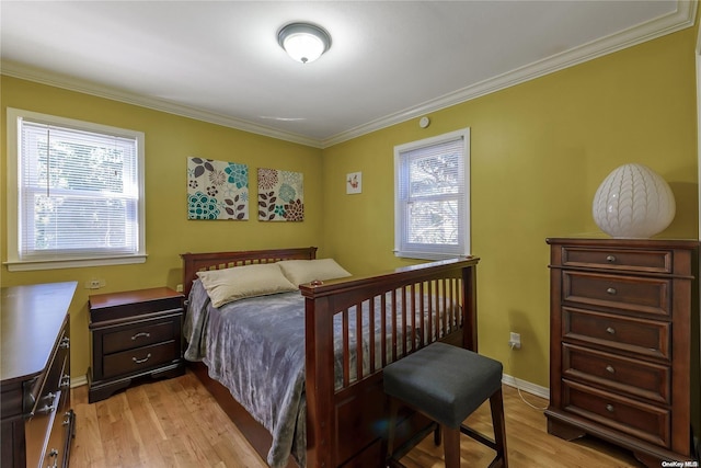 bedroom with light wood-type flooring, baseboards, and crown molding