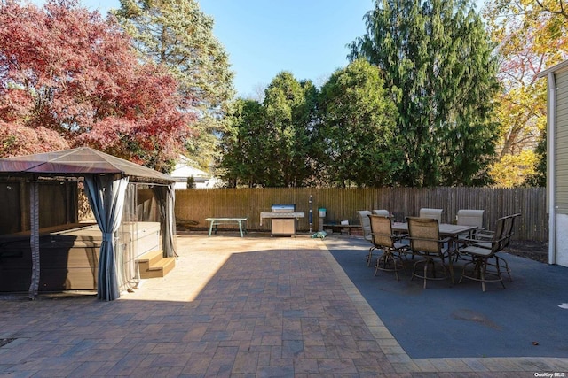 view of patio featuring a gazebo, outdoor dining area, and fence