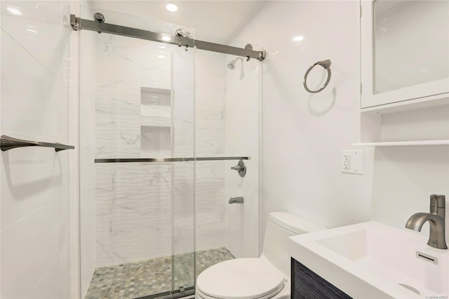 bathroom with vanity, toilet, and a shower with shower door