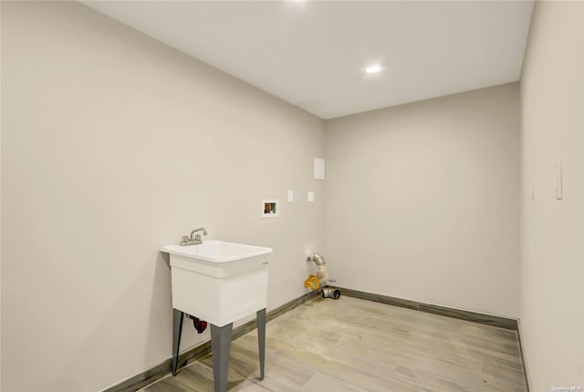 clothes washing area featuring washer hookup and light wood-type flooring