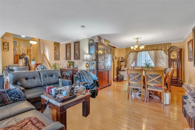 living room with a notable chandelier, light wood-type flooring, and ornamental molding