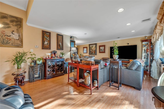 living room with wood-type flooring and ornamental molding