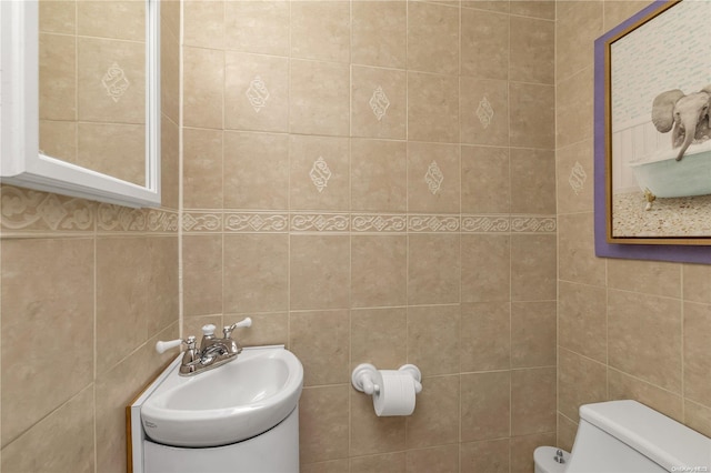 bathroom featuring tile walls and toilet