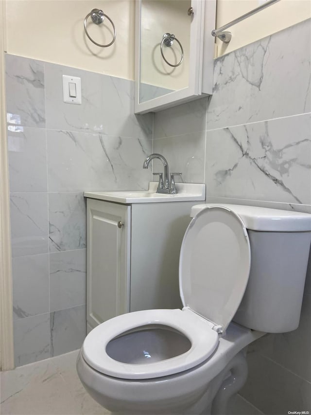 bathroom featuring backsplash, vanity, tile walls, and toilet