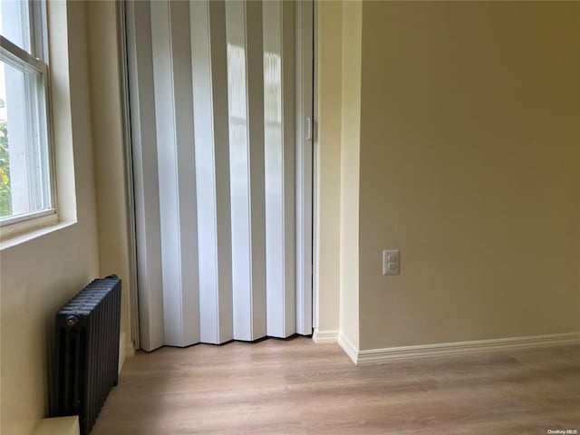 interior details with hardwood / wood-style flooring and radiator