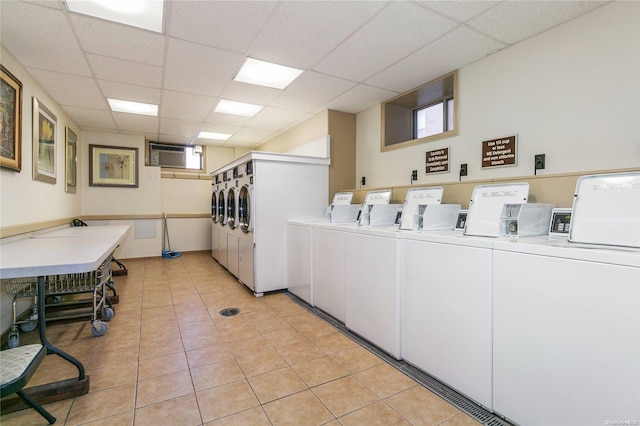 washroom featuring a wall mounted AC, separate washer and dryer, and light tile patterned floors