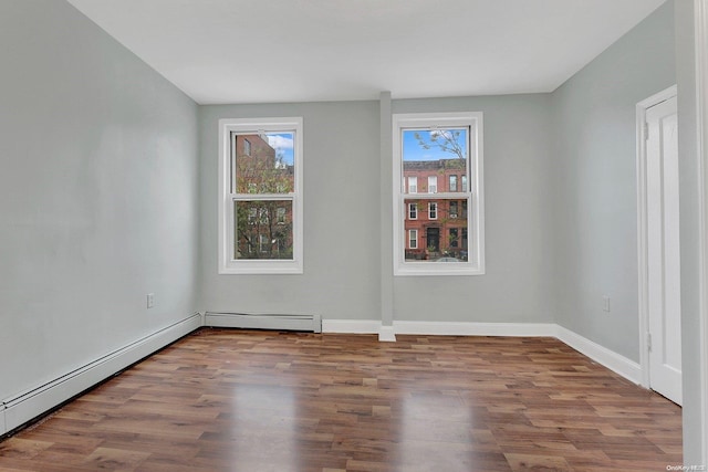 unfurnished room featuring hardwood / wood-style floors and a baseboard radiator