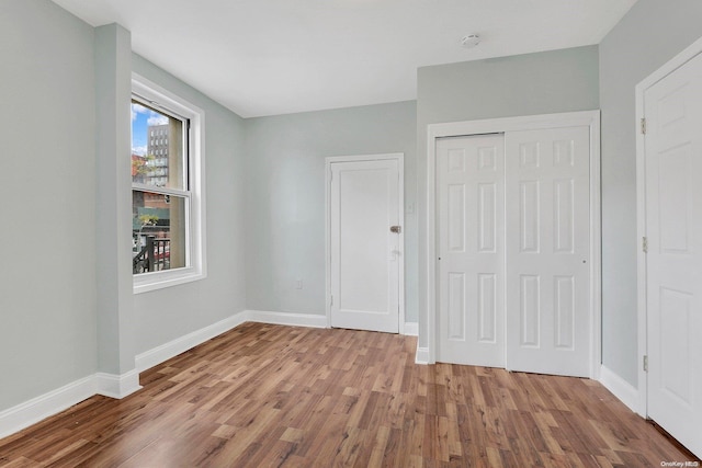 unfurnished bedroom featuring a closet and light wood-type flooring