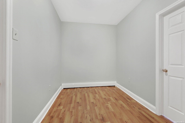 spare room featuring light wood-type flooring and a baseboard radiator