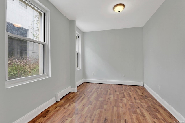 unfurnished room with light wood-type flooring and baseboard heating