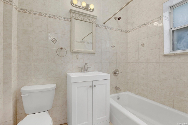 full bathroom featuring tiled shower / bath combo, toilet, tile walls, and vanity