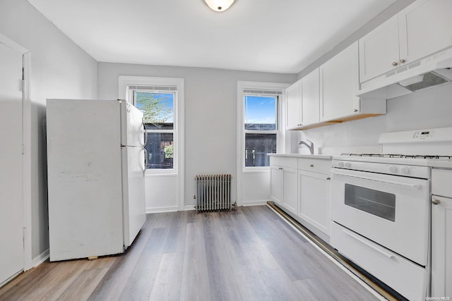 kitchen with white appliances, white cabinets, sink, light hardwood / wood-style flooring, and radiator heating unit