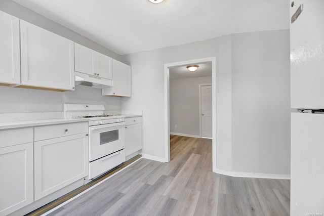 kitchen featuring white cabinets, light hardwood / wood-style floors, and white stove