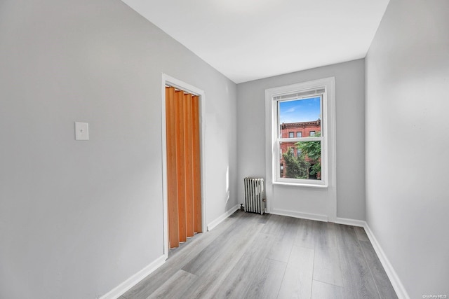 spare room featuring light hardwood / wood-style floors and radiator