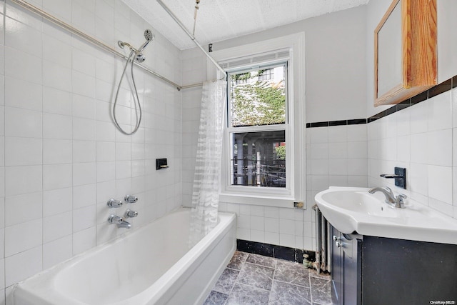 bathroom with tile patterned floors, vanity, shower / bathtub combination with curtain, and tile walls