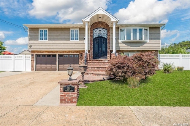 split foyer home featuring a garage and a front lawn