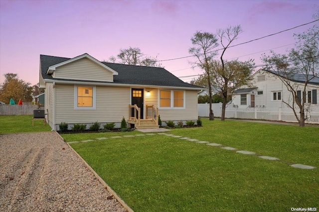 view of front of house with a yard and cooling unit