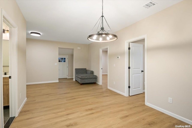 interior space featuring light wood-type flooring and an inviting chandelier