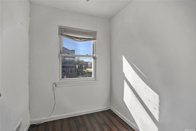 unfurnished room with dark wood-type flooring