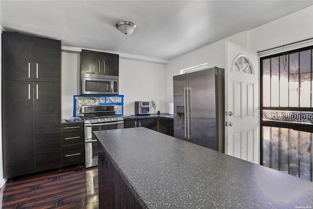 kitchen featuring backsplash, dark wood-type flooring, and appliances with stainless steel finishes