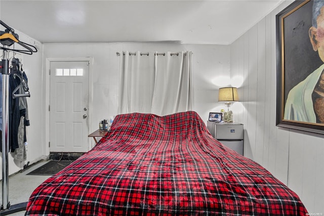 carpeted bedroom featuring wooden walls