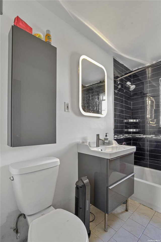 full bathroom featuring toilet, vanity, tile patterned floors, and tiled shower / bath