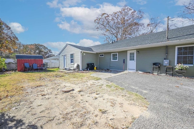 rear view of house with a storage unit