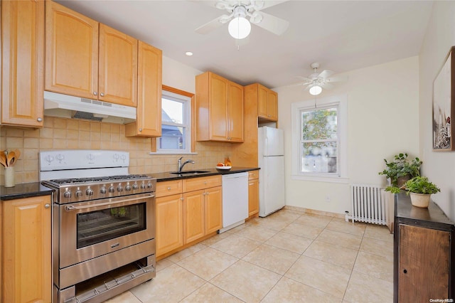 kitchen with white appliances, backsplash, radiator, sink, and light tile patterned floors