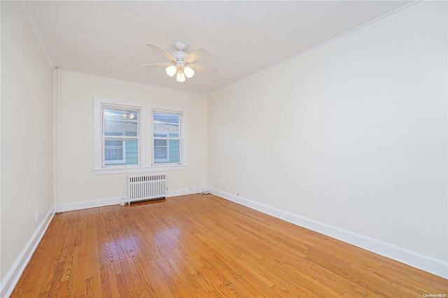 empty room featuring ceiling fan, light hardwood / wood-style floors, crown molding, and radiator