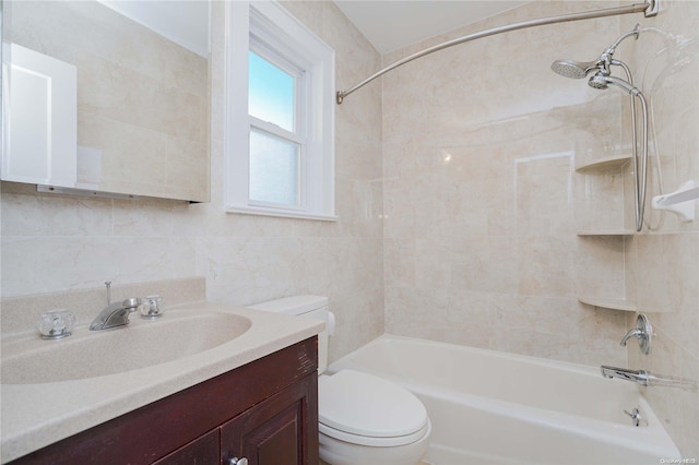 full bathroom with tiled shower / bath, vanity, toilet, and tile walls