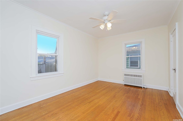 empty room with light wood-type flooring, radiator, crown molding, and ceiling fan