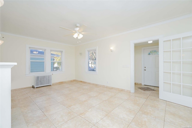 tiled empty room with radiator, ceiling fan, and ornamental molding