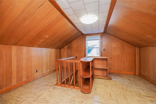 additional living space with vaulted ceiling, wooden walls, and light parquet flooring