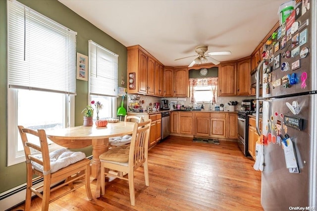 kitchen featuring tasteful backsplash, ceiling fan, light wood-type flooring, and appliances with stainless steel finishes