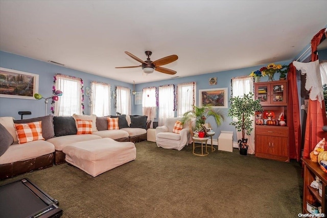 living room with ceiling fan and dark colored carpet