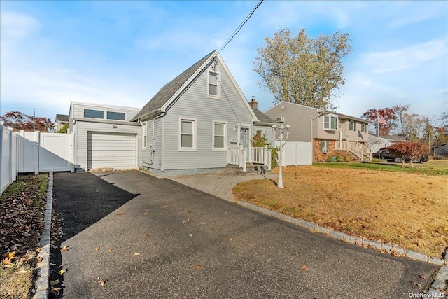 view of front of property with a garage and a front lawn