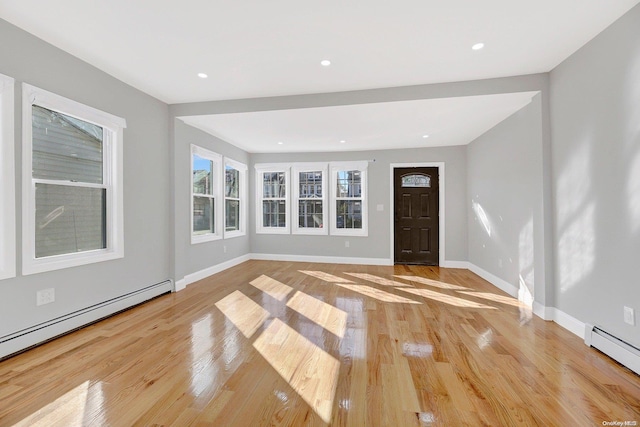 foyer featuring baseboard heating and light hardwood / wood-style floors