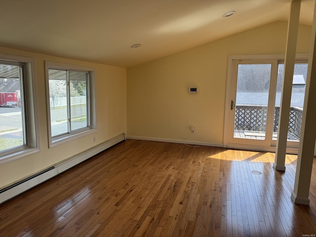 spare room with dark wood-type flooring, vaulted ceiling, baseboards, and baseboard heating