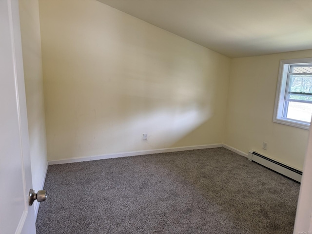 carpeted empty room featuring a baseboard heating unit and baseboards